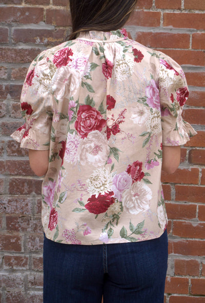 Women’s floral print top with smocked bodice, V-neckline, short puff sleeves, and ruffle trim details