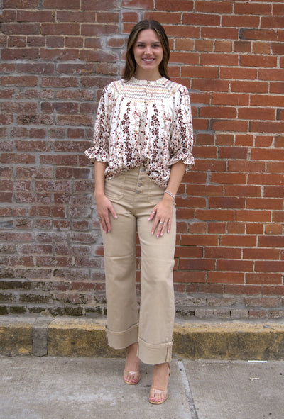 Women’s vibrant floral top with smocked yoke, zig-zag stitching, puff sleeves, and button-front detail