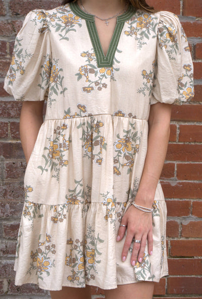 Women’s floral mini dress with short puff sleeves, V-neckline, and side pockets.