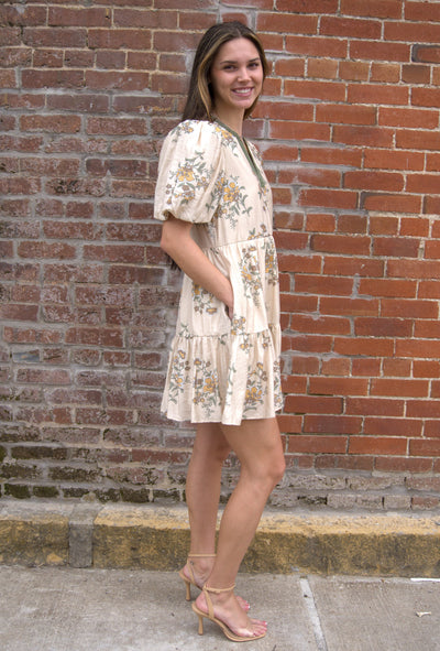 Women’s floral mini dress with short puff sleeves, V-neckline, and side pockets.