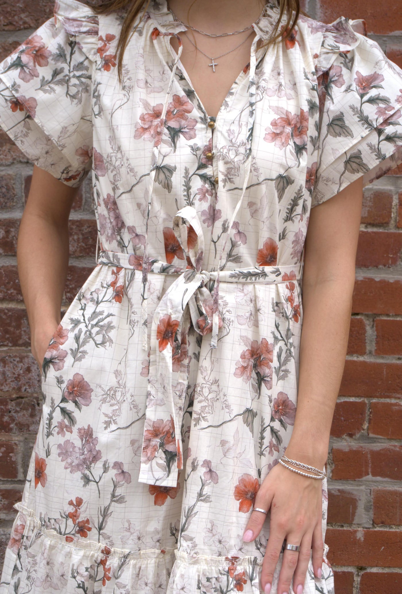 Women’s floral midi dress with flutter sleeves, ruffled V-neckline with tie, adjustable waist, and side pockets.